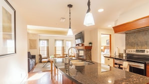 A spacious kitchen with a large island, granite countertops, and modern appliances.
