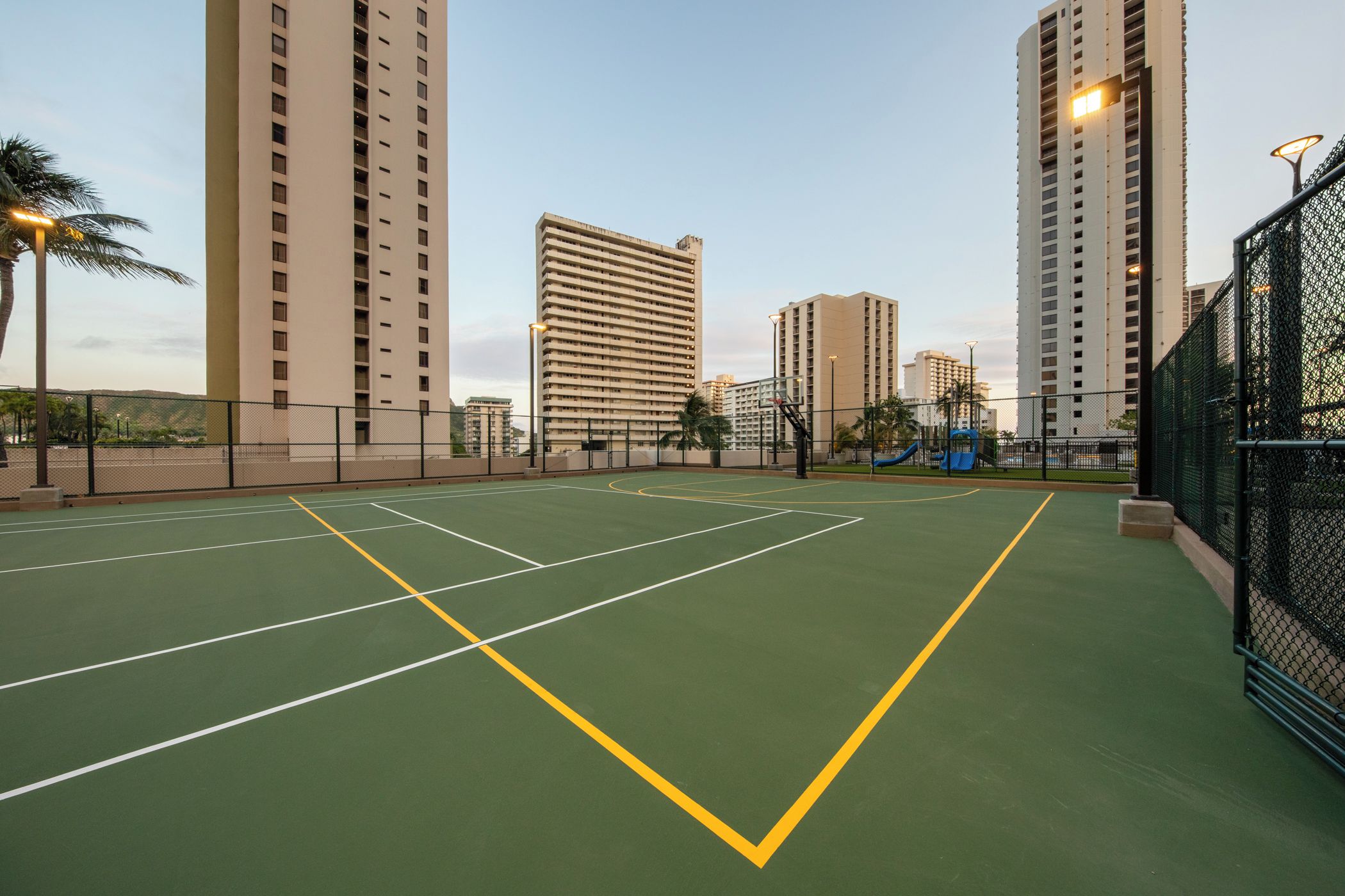 Una cancha de baloncesto al aire libre rodeada de edificios altos.