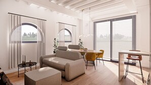 Una sala de estar moderna con un sofá, un reposapiés, una mesa de comedor, sillas y una mesita auxiliar.