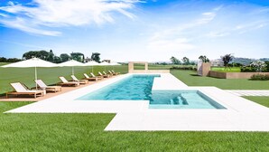 A rectangular swimming pool with a white deck, surrounded by a grassy area with lounge chairs and umbrellas. - Best Of Tuscany between Chianti, Pisa, Florence 7 (San Miniato Basso)