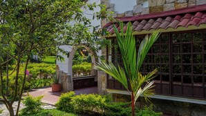 Un edificio tradicional con paredes de piedra, techo de tejas y una ventana con diseño de cuadrícula.