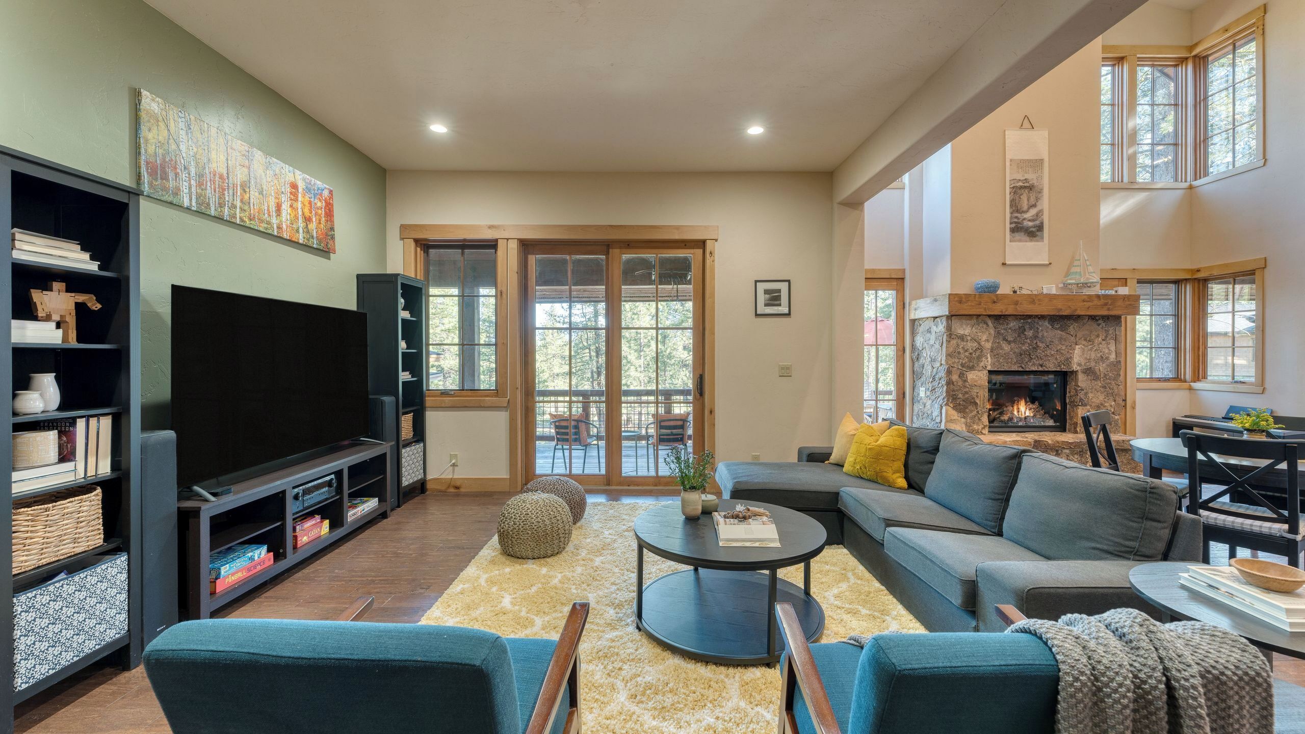 Una sala de estar con chimenea, televisor y estantería.