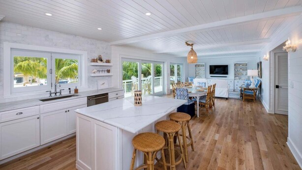 A spacious kitchen with a large island, wooden flooring, and a view of the outdoors. - PARADISE SHORES (Islamorada)