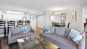 A modern living room with two grey sofas, a glass coffee table, and a dining area with a white table and chairs. - Come enjoy sun and sand in Naples luxury-WS0803 (Naples)