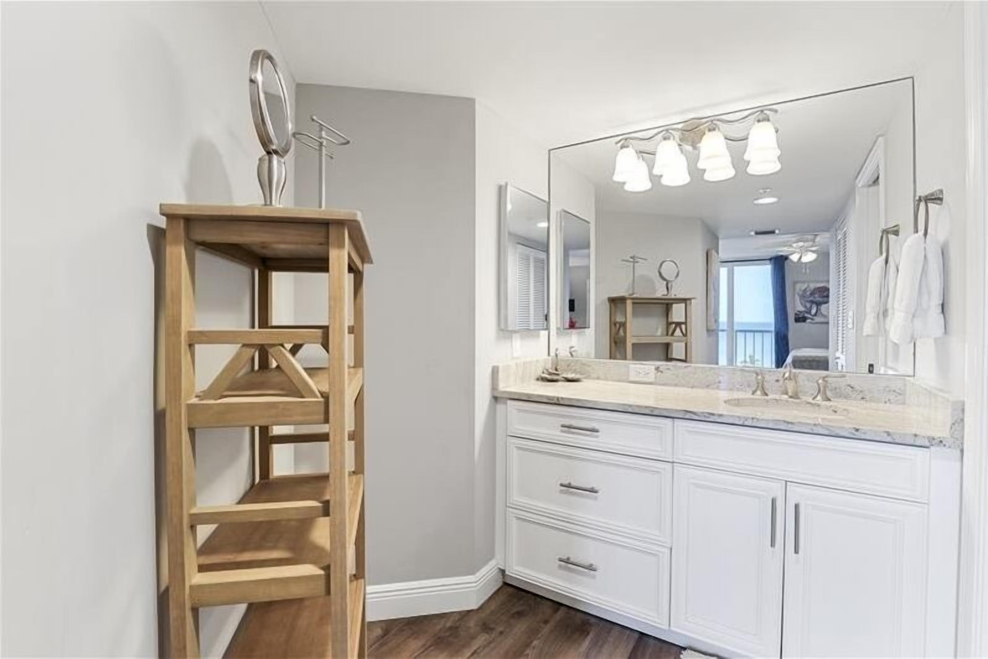 Un bagno con ripiano in legno, un ampio specchio, un mobile lavabo e una lampada a soffitto.