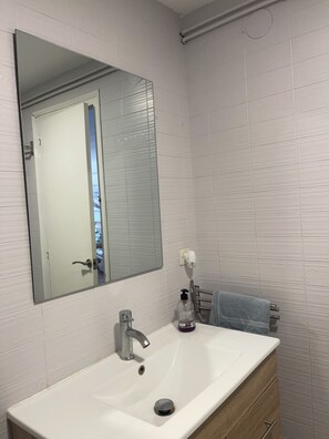 Een douche, handdoeken, zeep, shampoo