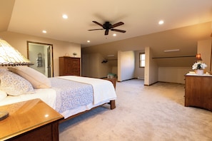 A spacious bedroom with a large bed, a ceiling fan, and a walk-in closet. - Secluded and spacious Barndominium close to 2 Ski Resorts and many attractions! (Factoryville)