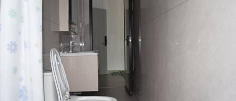 A modern bathroom with a toilet, sink, and shower area.