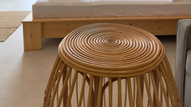 A bedroom with a large bed, a wooden bench, and a view of greenery through the window. - Rue Rooms (Fethiye)