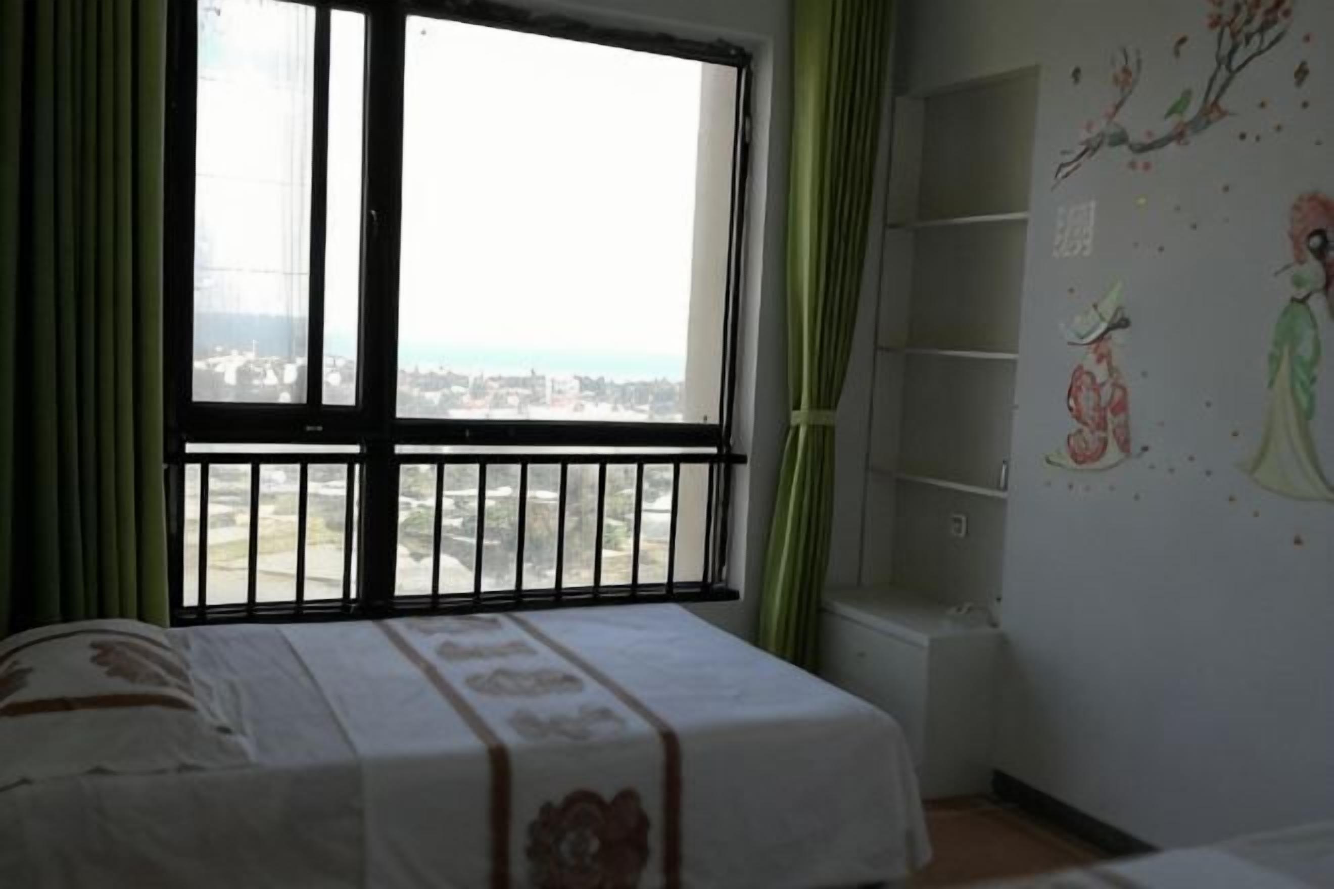 Un dormitorio con cama, ventana con vistas y una pared decorada con obras de arte.