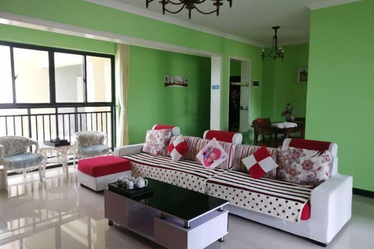 A living room with a sofa, chairs, a coffee table, and a dining area with a table and chairs.