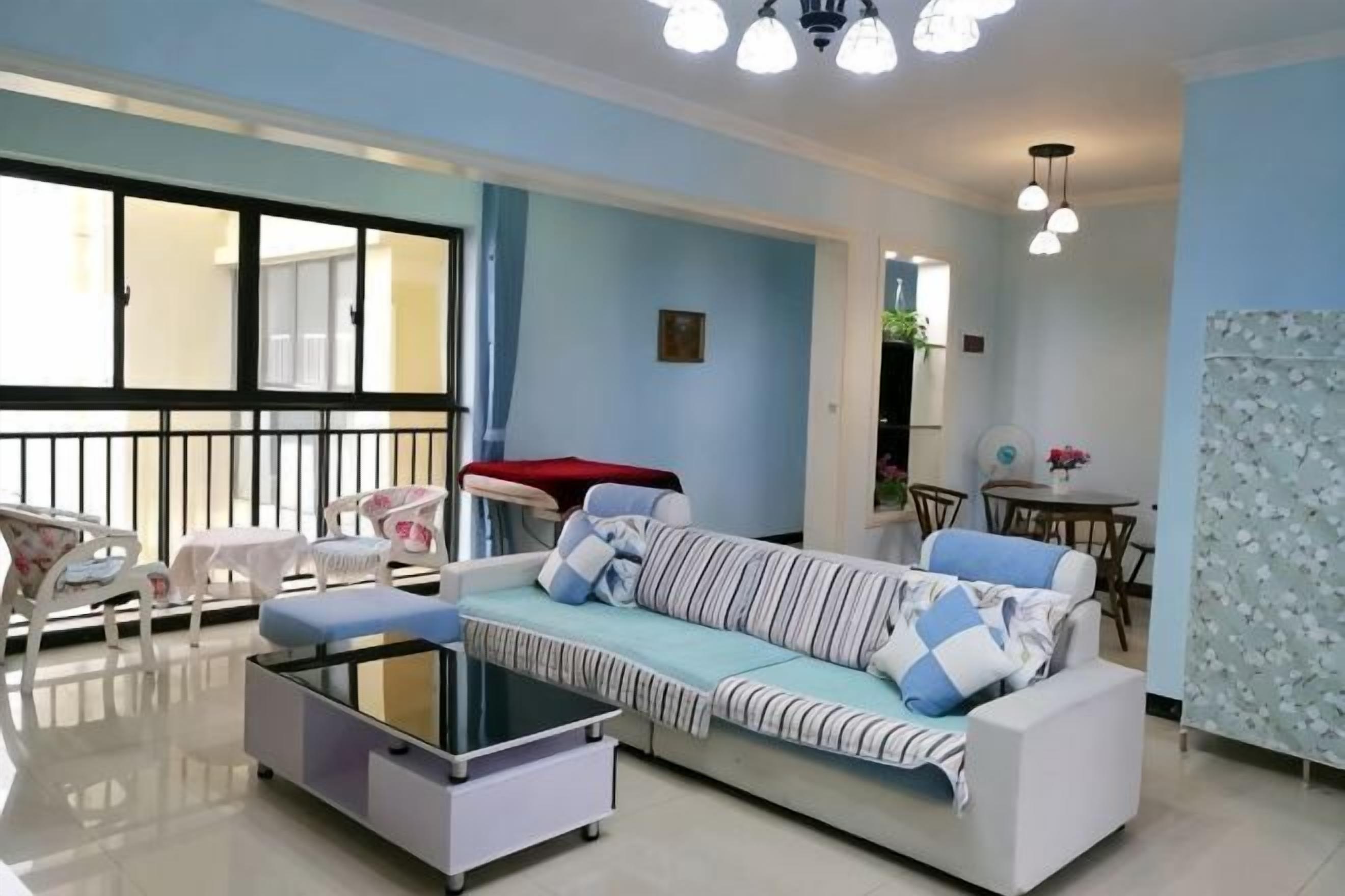 Uma sala de estar com sofá, mesa de centro e área de jantar com cadeiras e mesa.