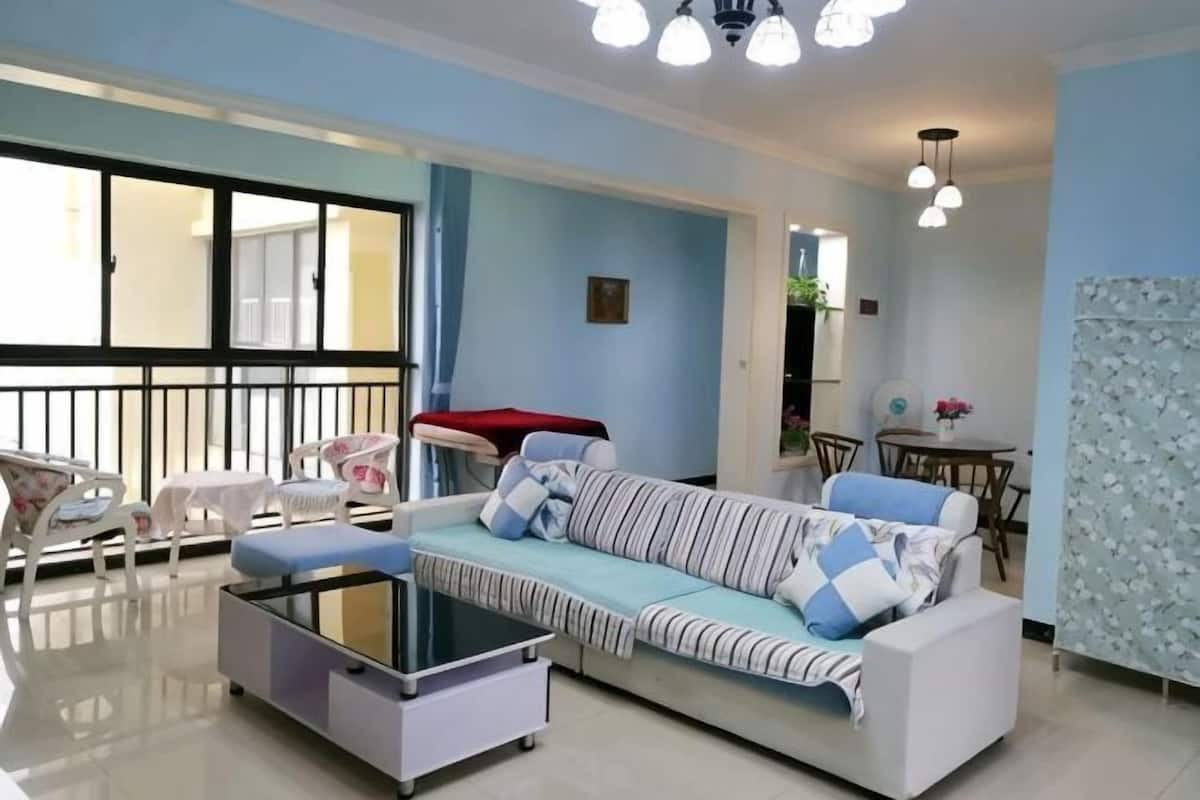 Uma sala de estar com sofá, mesa de centro e área de jantar com cadeiras e mesa.