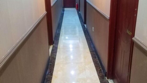 A hallway with a marble floor and wooden doors. - Yiting Hotel Loudi (Loudi)