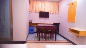 A hotel room with two beds, a dining table with chairs, a television mounted on the wall, and a small stool. - Yiting Hotel Loudi (Loudi)