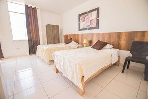 Habitación de hotel con dos camas, cabecero de madera, una obra de arte en la pared y una silla.