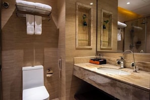 A modern bathroom with a marble vanity, a glass shower enclosure, and a toilet. - Wanjia Oriental Hotel (Jinjiang)