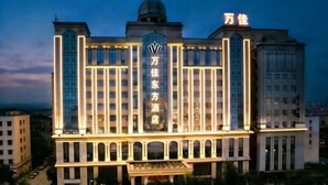 Un hotel con un cartel central llamativo, varios pisos y una estructura en forma de cúpula en la parte superior.