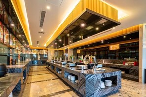 A modern hotel lobby with a long reception desk, seating area, and a large mirror. - Wanjia Oriental Hotel (Jinjiang)