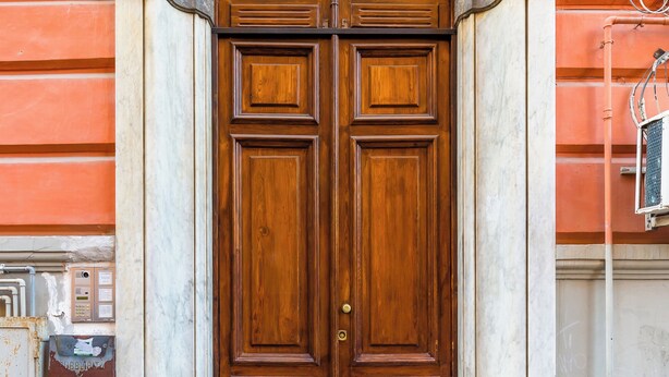 A large wooden double door with a stone archway, set in a building with a red facade. - Ferdinando Art House by Wonderful Italy (Naples)