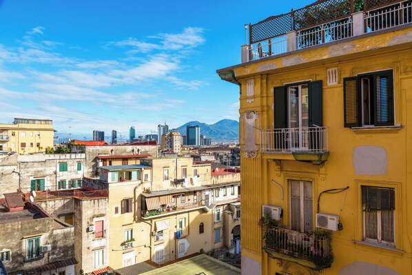 Un edificio amarillo con balcones y unidades de aire acondicionado.