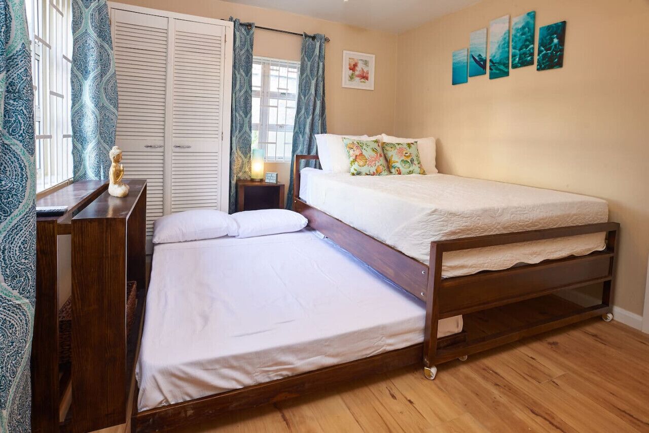 A bedroom with a wooden bed, a nightstand, a desk, and a wardrobe.