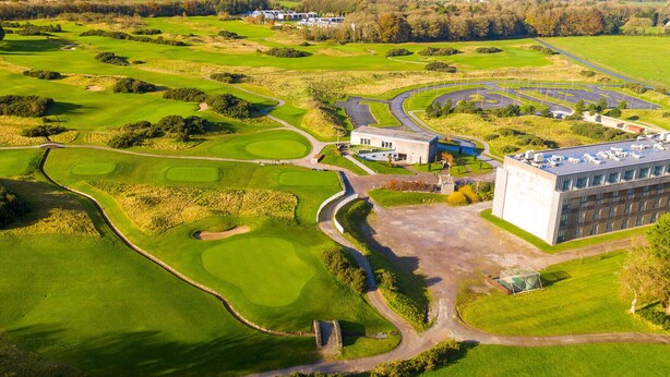 An aerial view of a golf course with a clubhouse, a parking area, and surrounding fields. - Castlemartyr Holiday Lodges No 3 (2 Bed) (Castlemartyr)
