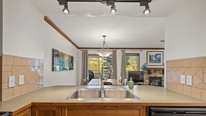 A modern kitchen with a double sink, wooden cabinets, and a dishwasher.
