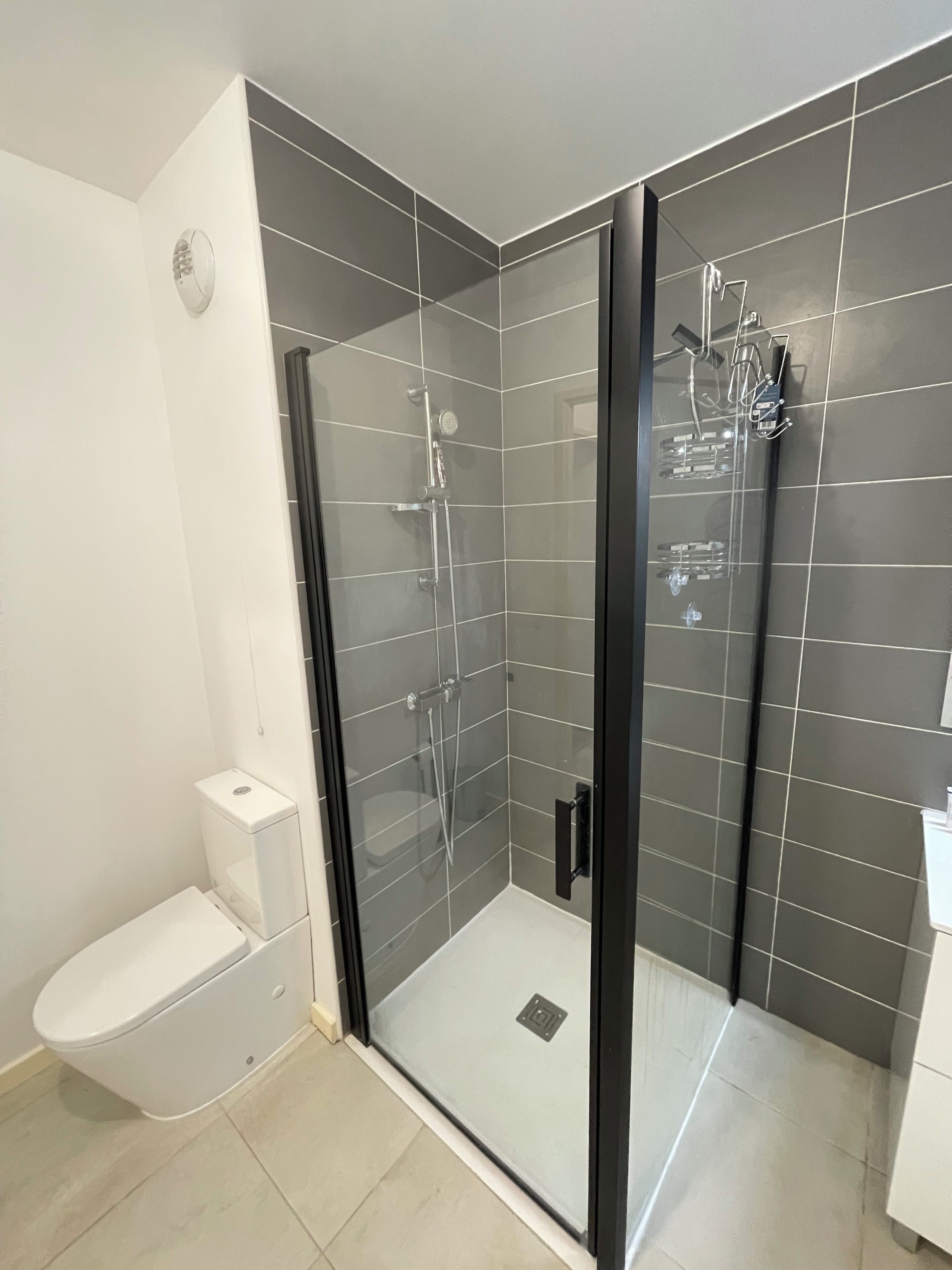 Een douche, handdoeken, zeep, shampoo