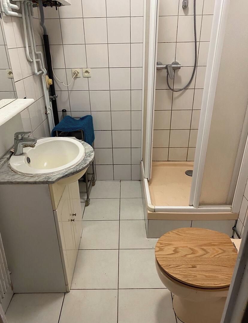 A compact bathroom with a sink, a shower, and a toilet.