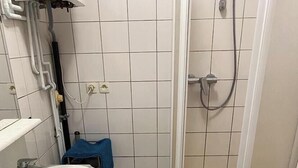 Une petite salle de bain comprenant un lavabo, une douche et des toilettes.