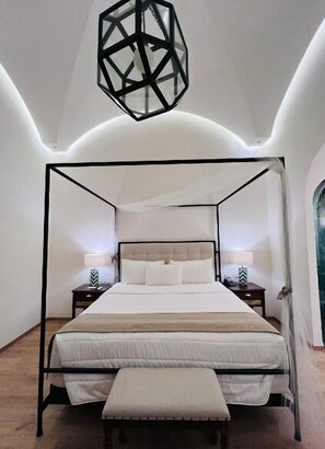 Restful retreat with a four-poster bed and bedside tables, each with a lamp.