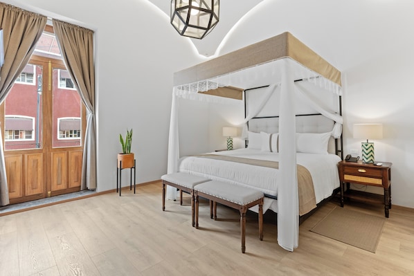 Cozy retreat with a four-poster bed, bench, and bedside table, offering a peaceful view.