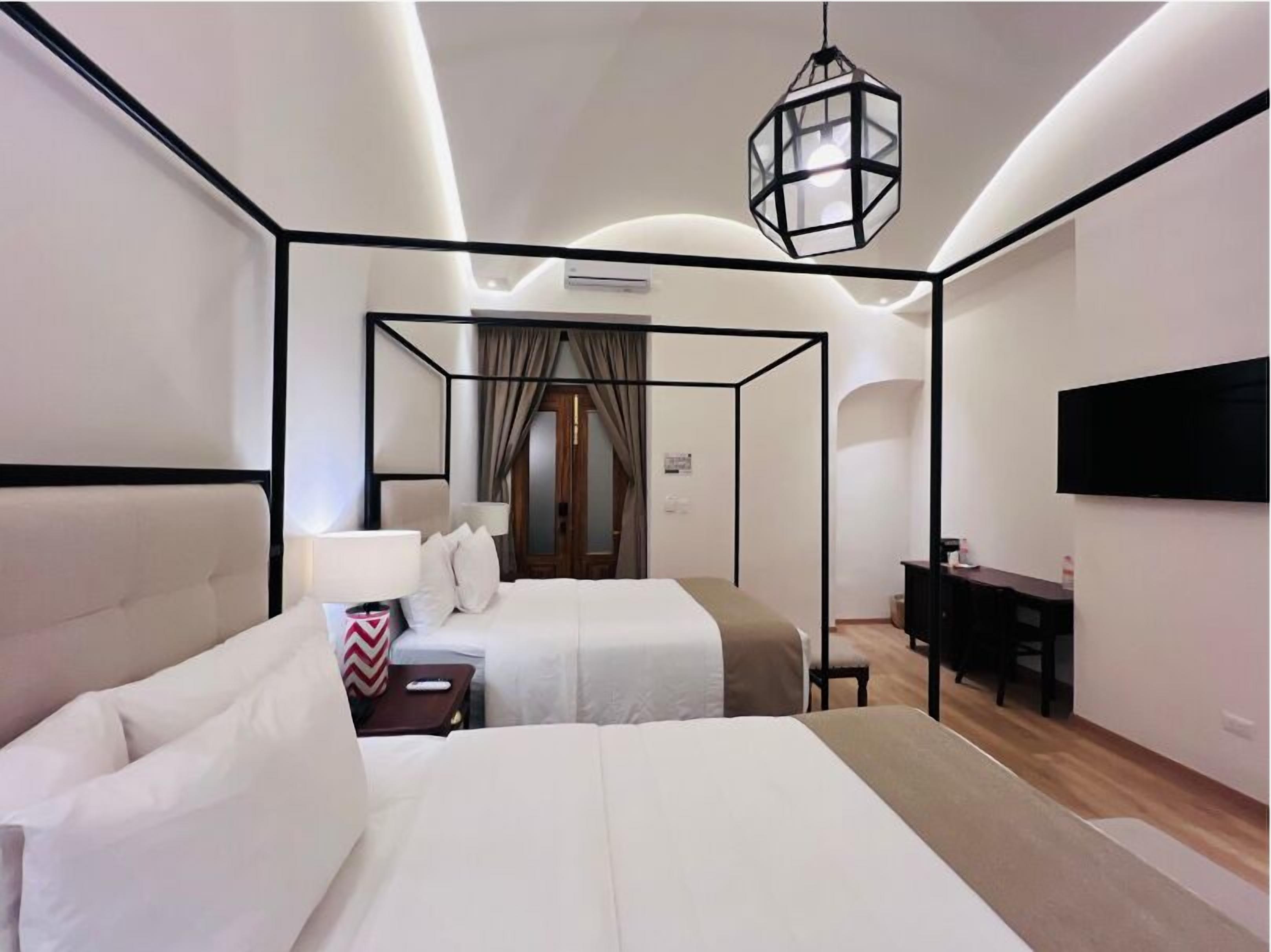 Una habitación de hotel moderna con una cama grande, un escritorio y un televisor.