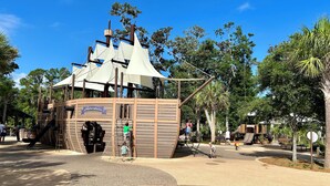 Un espace de jeux sur le thème des pirates, avec des structures d’escalade et un bâtiment en forme de navire.