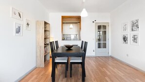 A dining area with a dark wooden table, six chairs, and a hanging light fixture. - Dream Views of Porto - Private Apt in Gaia by Lisbeyond (Vila Nova de Gaia)