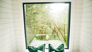 A room with a large window offering a view of a forested area. - Unique Cabin on the Beechfork River, nestled in the heart of the Bourbon Trail  (Springfield)