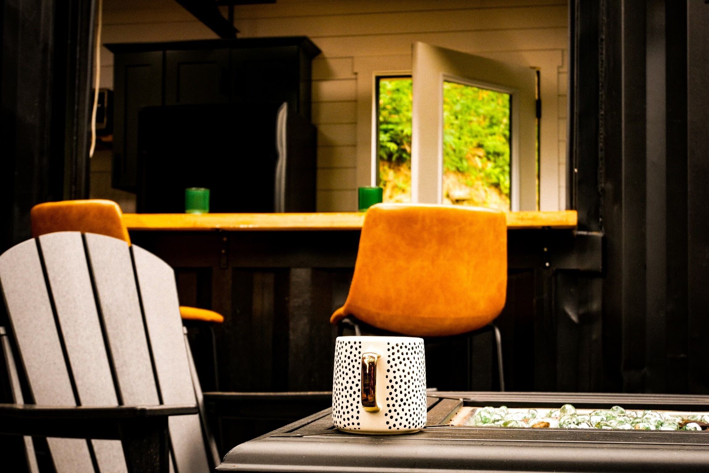 Eine Küche mit Fenster, einem Tisch mit Tasse und zwei Stühlen.