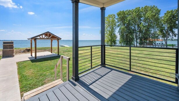 A covered outdoor area with a wooden gazebo, a metal railing, and a view of the sea. - Site 93 @ Peninsula point (Kerens)