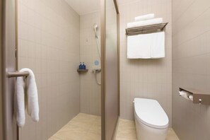Casa de banho com chuveiro, sanita e porta-toalhas.