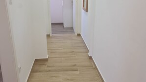 A narrow hallway with wooden flooring and white walls. - Apartments Rubbi - Two Bedroom Apartment with Terrace (Vrsi)