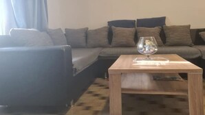 Een woonkamer met een bank, een salontafel en een glazen vaas.