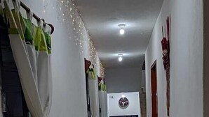 A hallway with blue and white walls, tiled floor, and curtains on the windows. - Hotel Taxco De Mis Amores (Taxco)