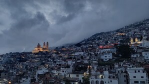 A densely packed urban landscape with a prominent cathedral and bell towers, surrounded by residential buildings. - Hotel Taxco De Mis Amores (Taxco)