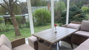 An outdoor patio with wicker furniture and a table. - Ferienhaus in Herzwolde für 4+2 Personen (Wokuhl-Dabelow)