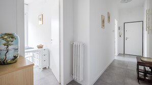 A bright hallway with white walls, a radiator, and a door leading to another room. - Appartamento Bernini in zona Sant'Orsola by Wonderful Italy (Bologna)