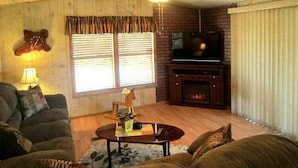 A cozy living room with a fireplace, a television, and a comfortable seating area.