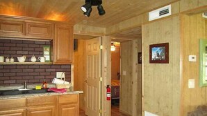 A kitchen with wooden cabinets, a brick backsplash, and a tiled floor.