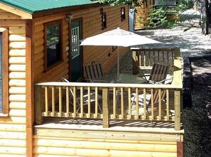 Une cabane en bois dotée d’une terrasse, d’un espace salon extérieur et d’un patio couvert.