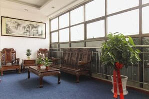 A room with a large window, a sofa, a table, and a potted plant. - Kuaizhilv Express Chain Hotel (Kunshan)